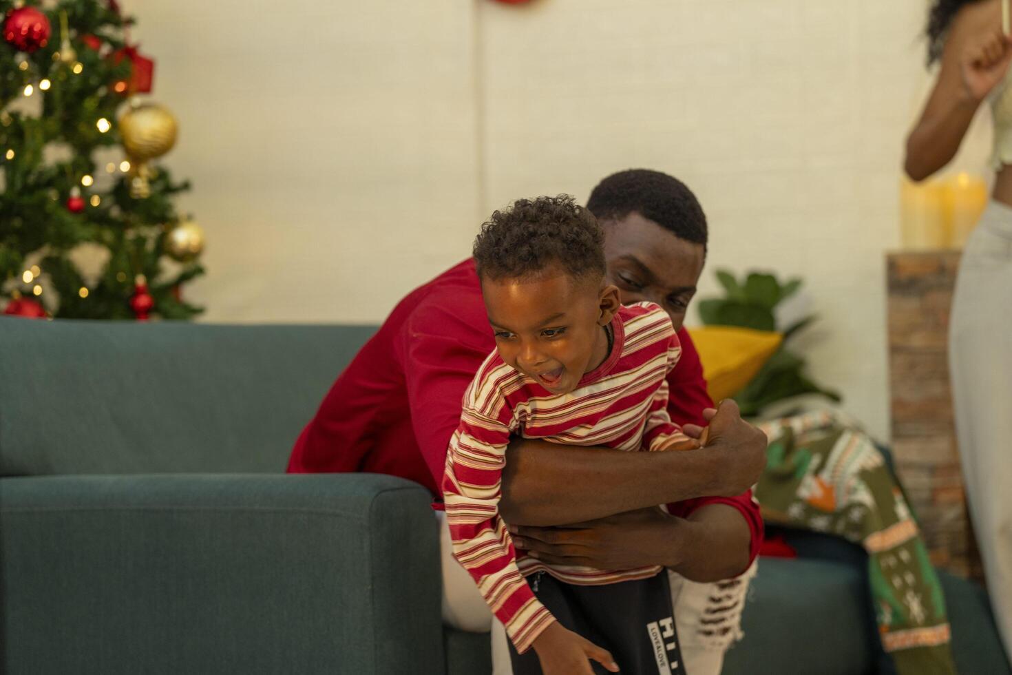 A family joyfully decorates a Christmas tree, hanging ornaments and festive decorations.The family members are engaged in adding the final touches to their beautiful Christmas tree. photo