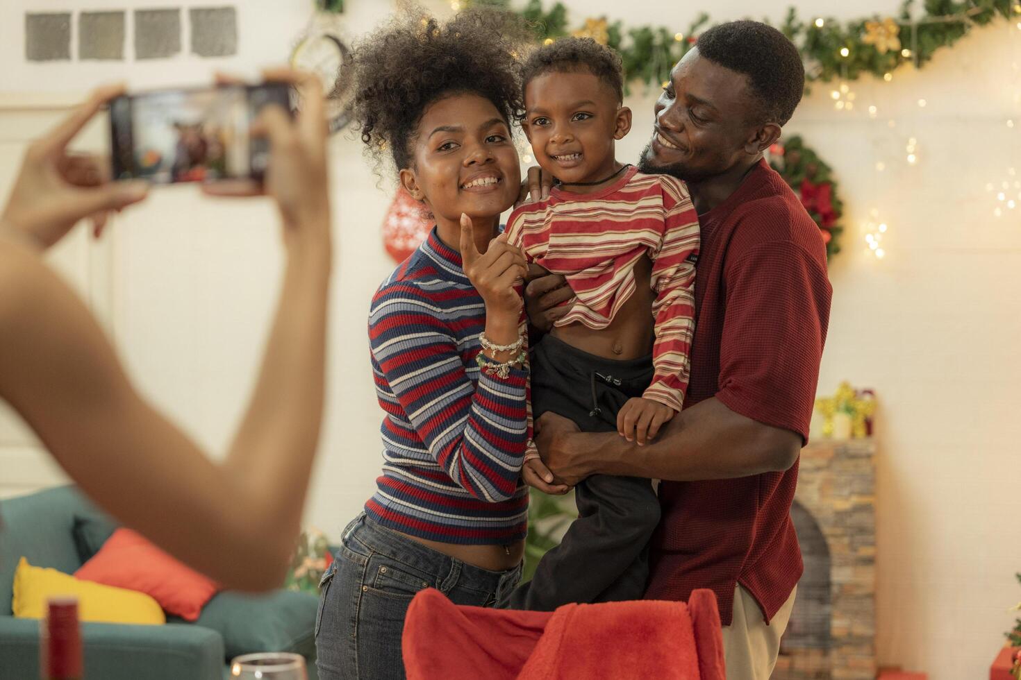 A joyful family gathers around the dinner table celebrating Christmas. The father, dressed in a Santa hat, gives a gift to the child, while everyone smiles with warmth and festive decorations. photo