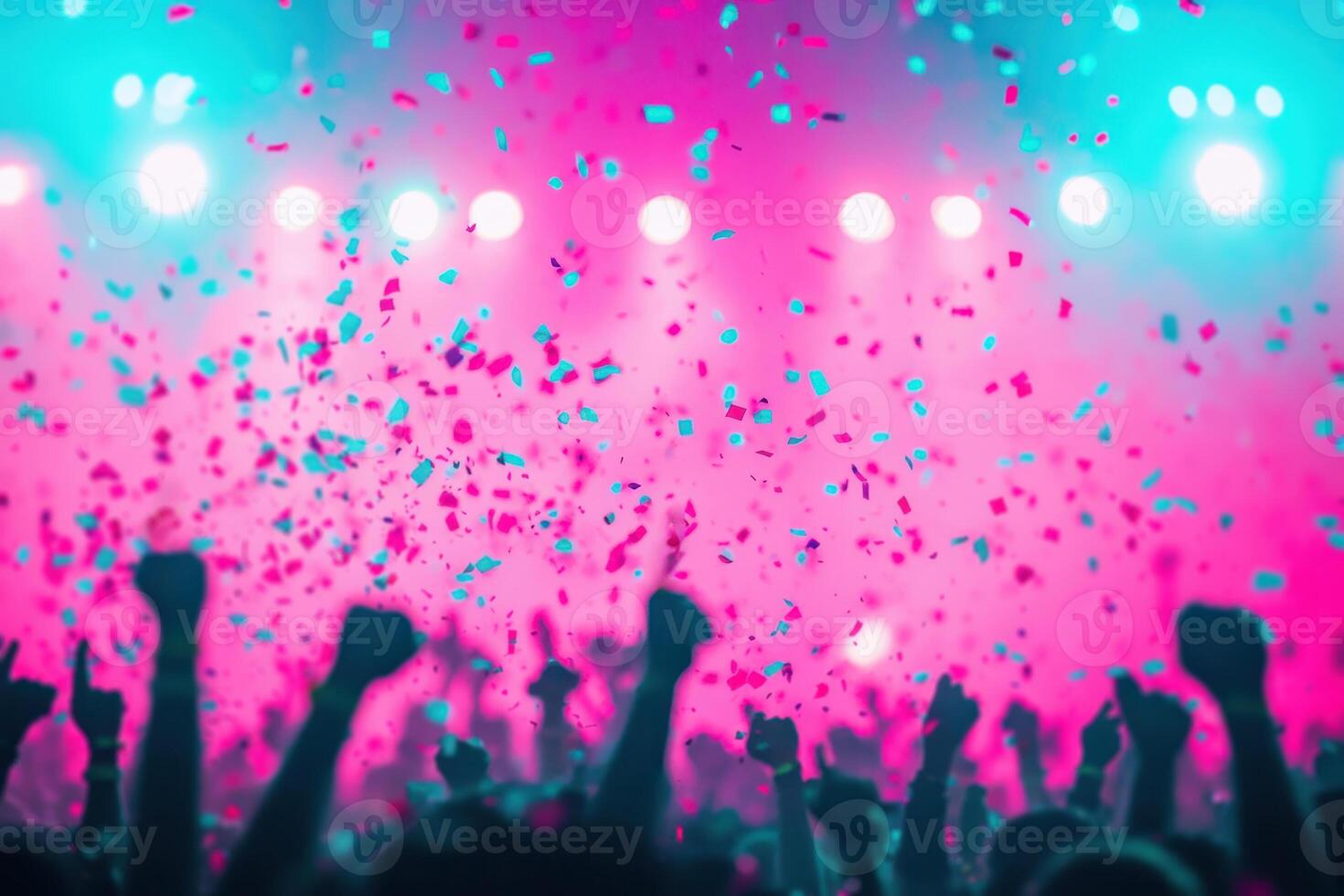 Crowd with hands up enjoying confetti falling down during a concert. Concept of celebration, party, entertainment, music festival, and nightlife. photo
