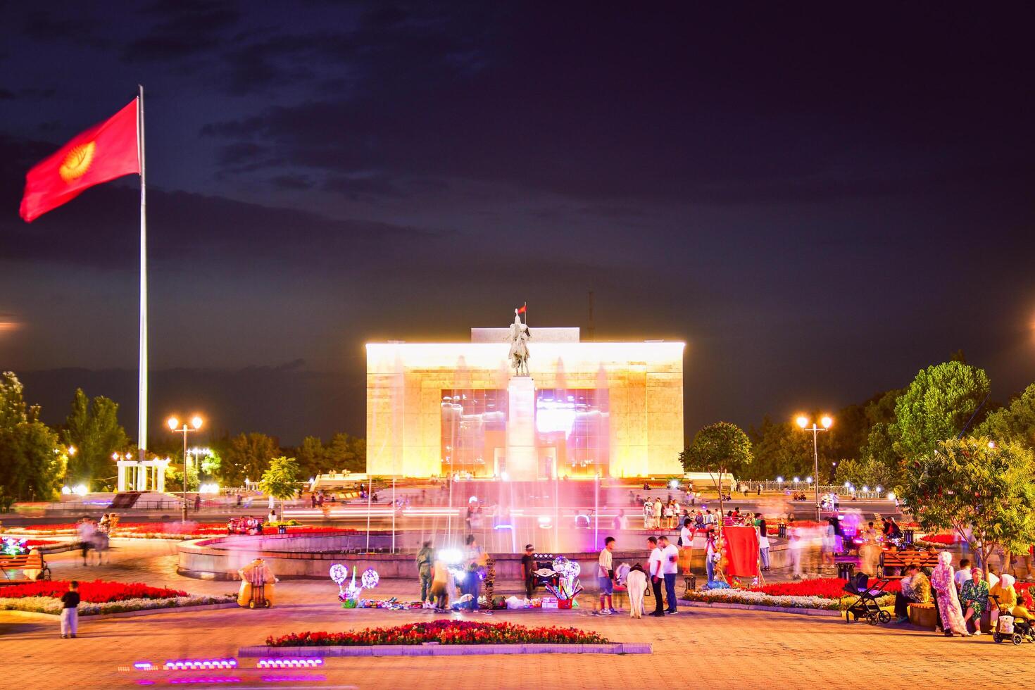 Bishkek, Kyrgyzstan - 25th september, 2023 - tourist visit famous popular Manas Statue in Ala-Too Square. State history museum and fountain with tourist in city square. Sunset blue hour sky background photo