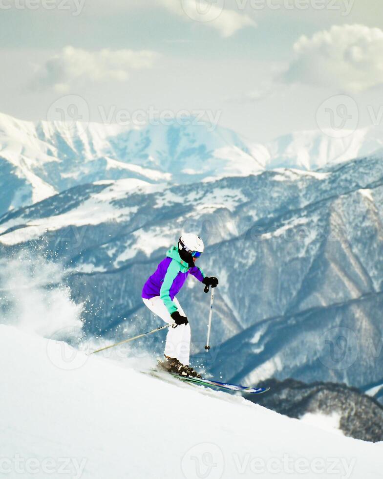 Dynamic picture of woman skier on the piste ski downhill fast motion in Alps. Active winter holidays, skiing downhill in overcast day. Ski rides on the track with swirls of fresh snow photo