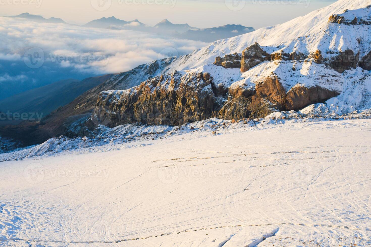 Aerial view close up Gergeti glacier tongue located on the southeastern slope of Mt. Kazbek. Kazbegi District of Georgia. Mount Kazbek climbing route. Caucasus mountain range snowy peaks photo