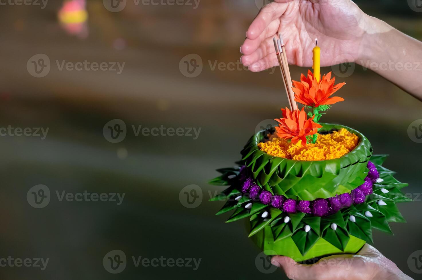 Hand holding krathong with candle and joss sticks ready to put on river for Thailand Loy Krathong festival. photo