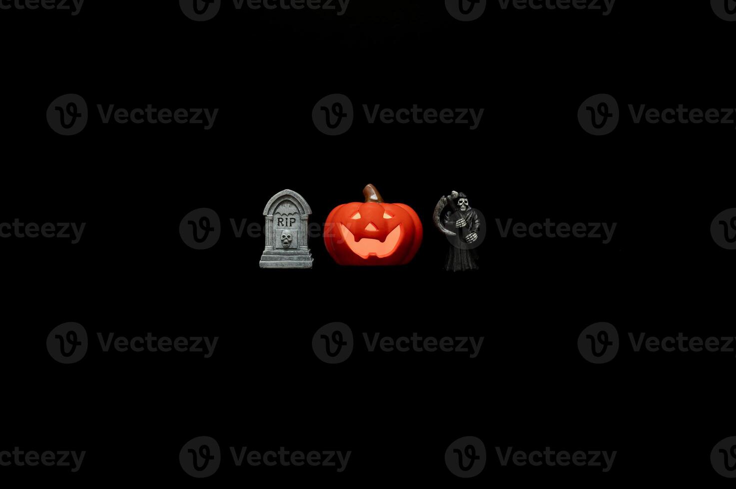 Halloween background with Jack o lantern that have light inside and small decorations on black background. Minimal concept. photo