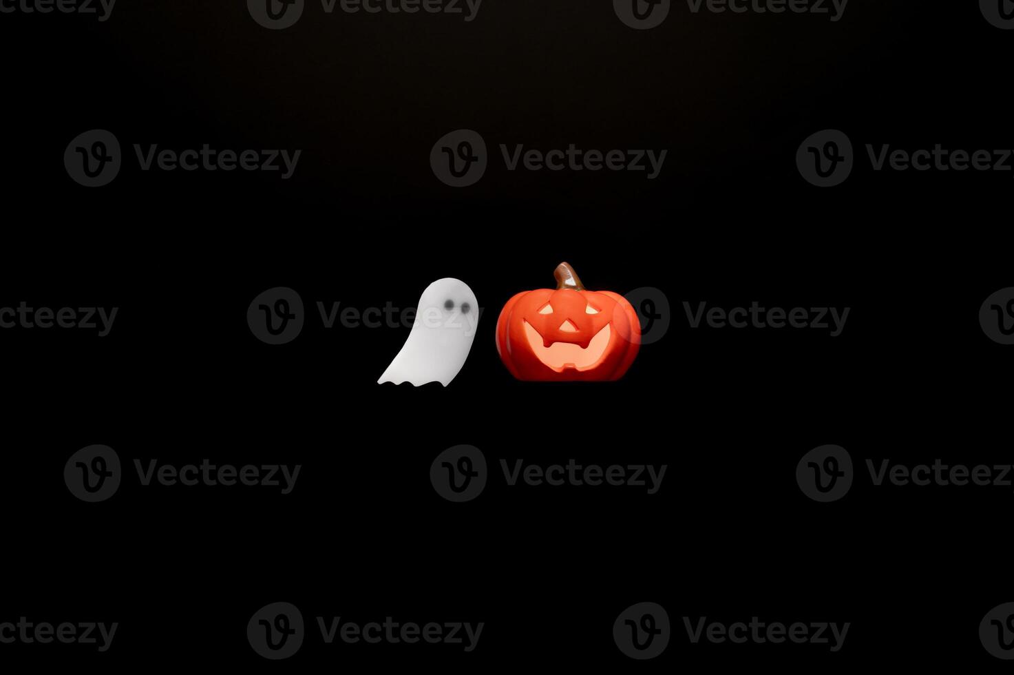 Halloween background with Jack o lantern that have light inside and white ghost sheet gel sticker on black background. Minimal concept. photo