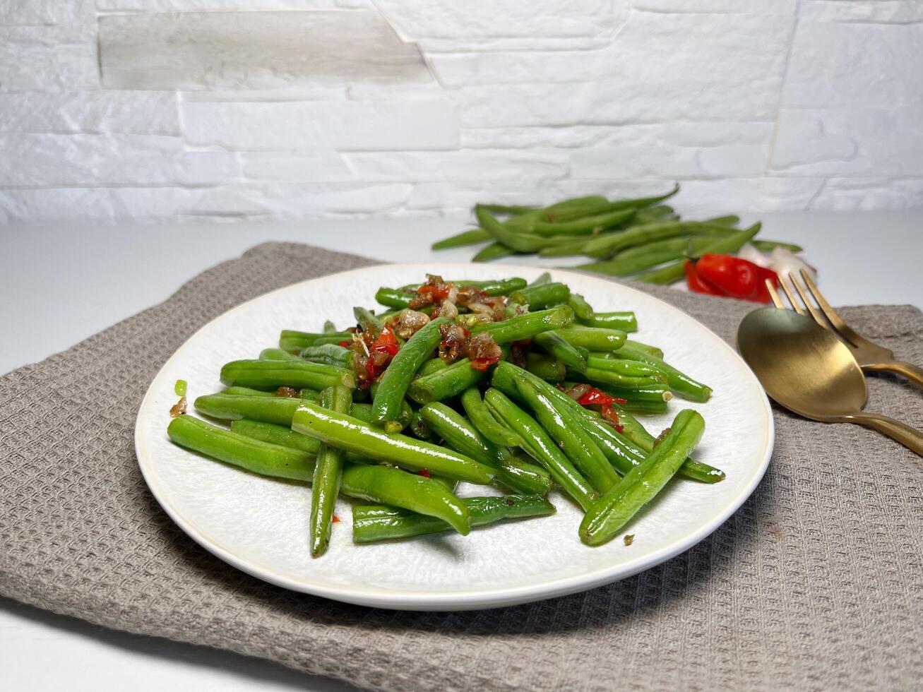 Spicy stir-fried green beans with garlic and chili on white plate. Asian style food. photo
