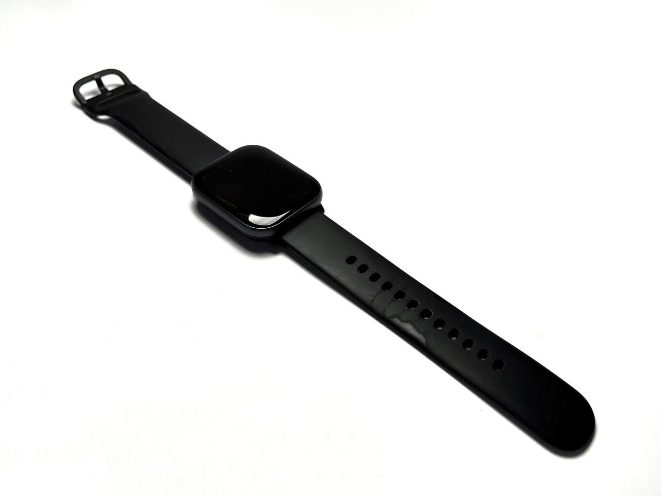 Black smart watch isolated on white background. Smartwatch that has been used with black strap. Copy space for text. photo