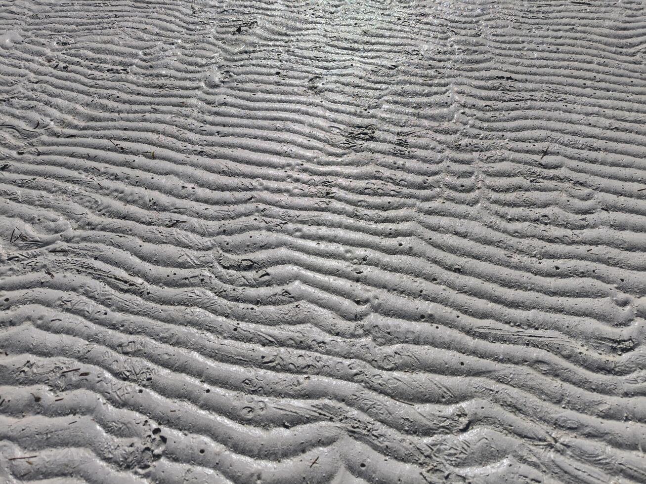 Sea sand has a unique texture due to the waves of sea water on the beach photo