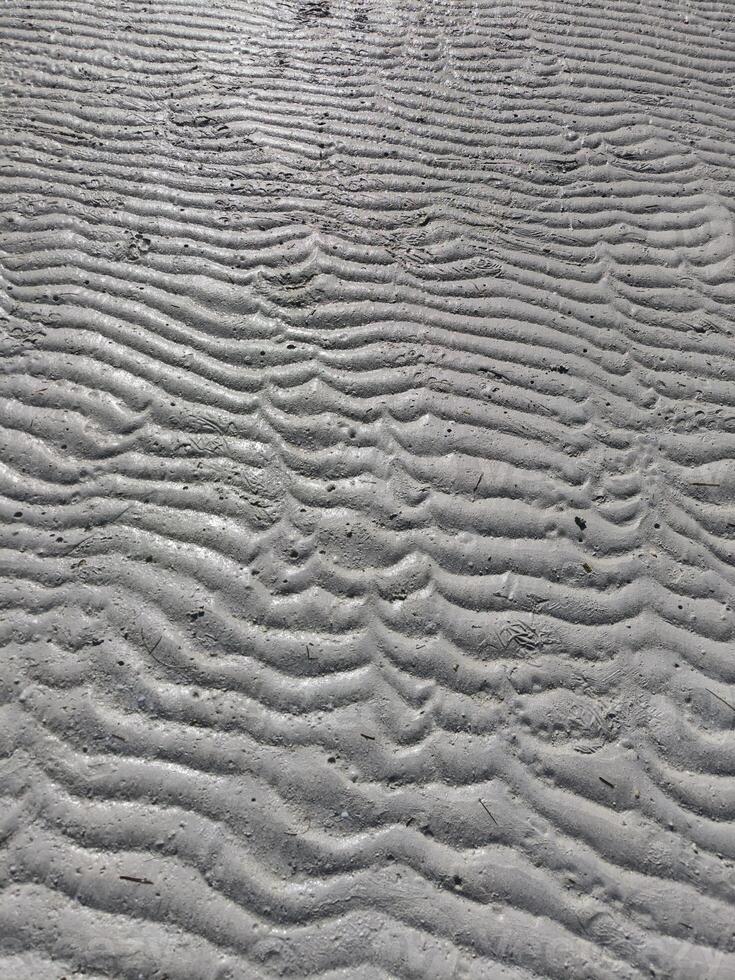 Sea sand has a unique texture due to the waves of sea water on the beach photo