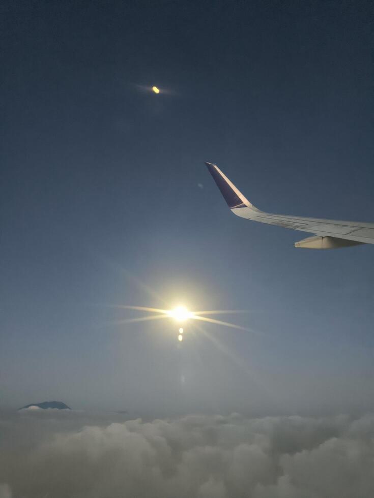 View from airplane window, wing tips, blue sky, white clouds, horizon, jet engine photo