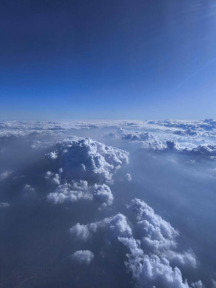 View from airplane window, wing tips, blue sky, white clouds, horizon, jet engine photo