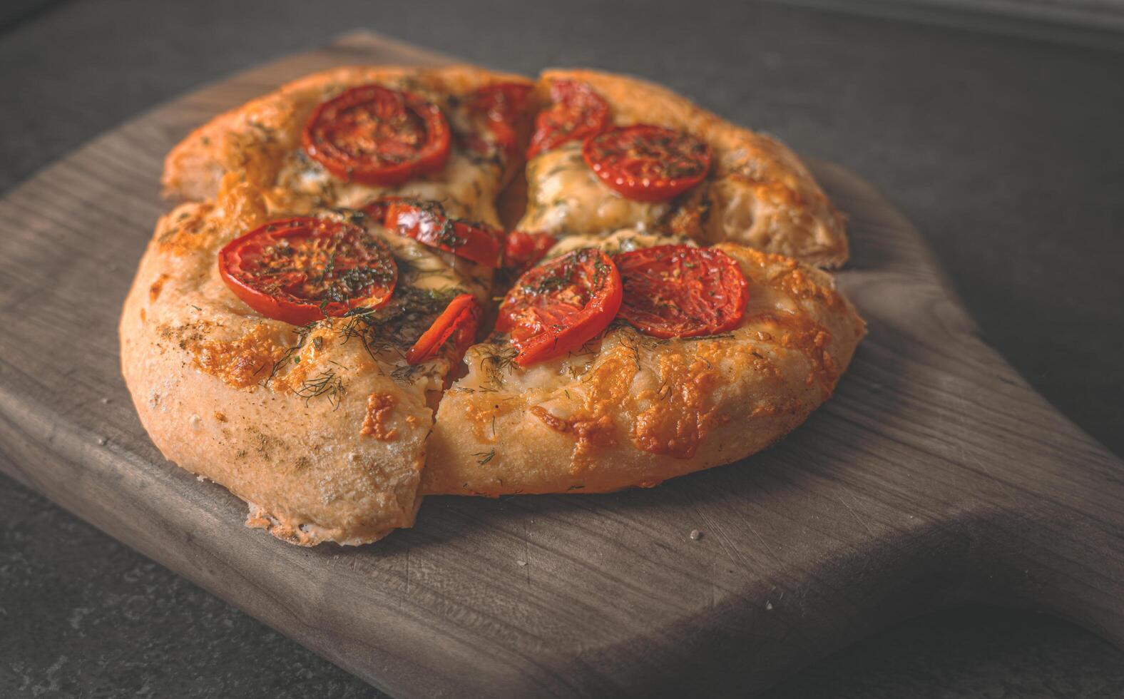 Lush homemade pizza cooked in an electric oven with tomatoes, spices and two types of cheese photo