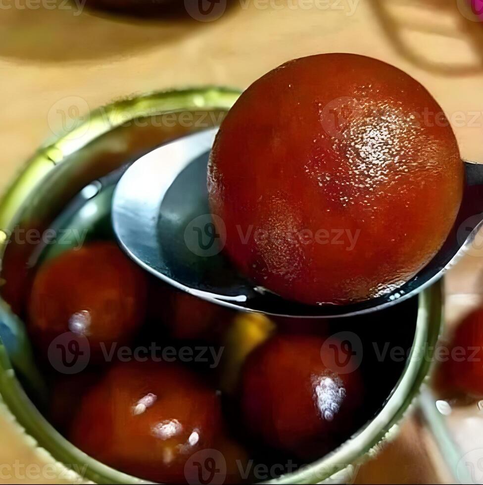 a spoon with Indian dessert Gulab jamun some in it photo