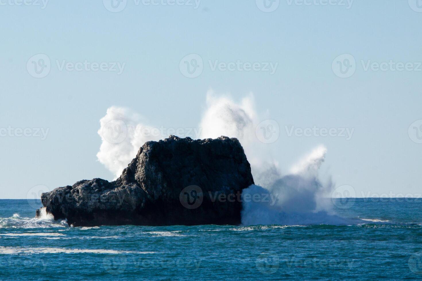 Waves crashing into a rock photo