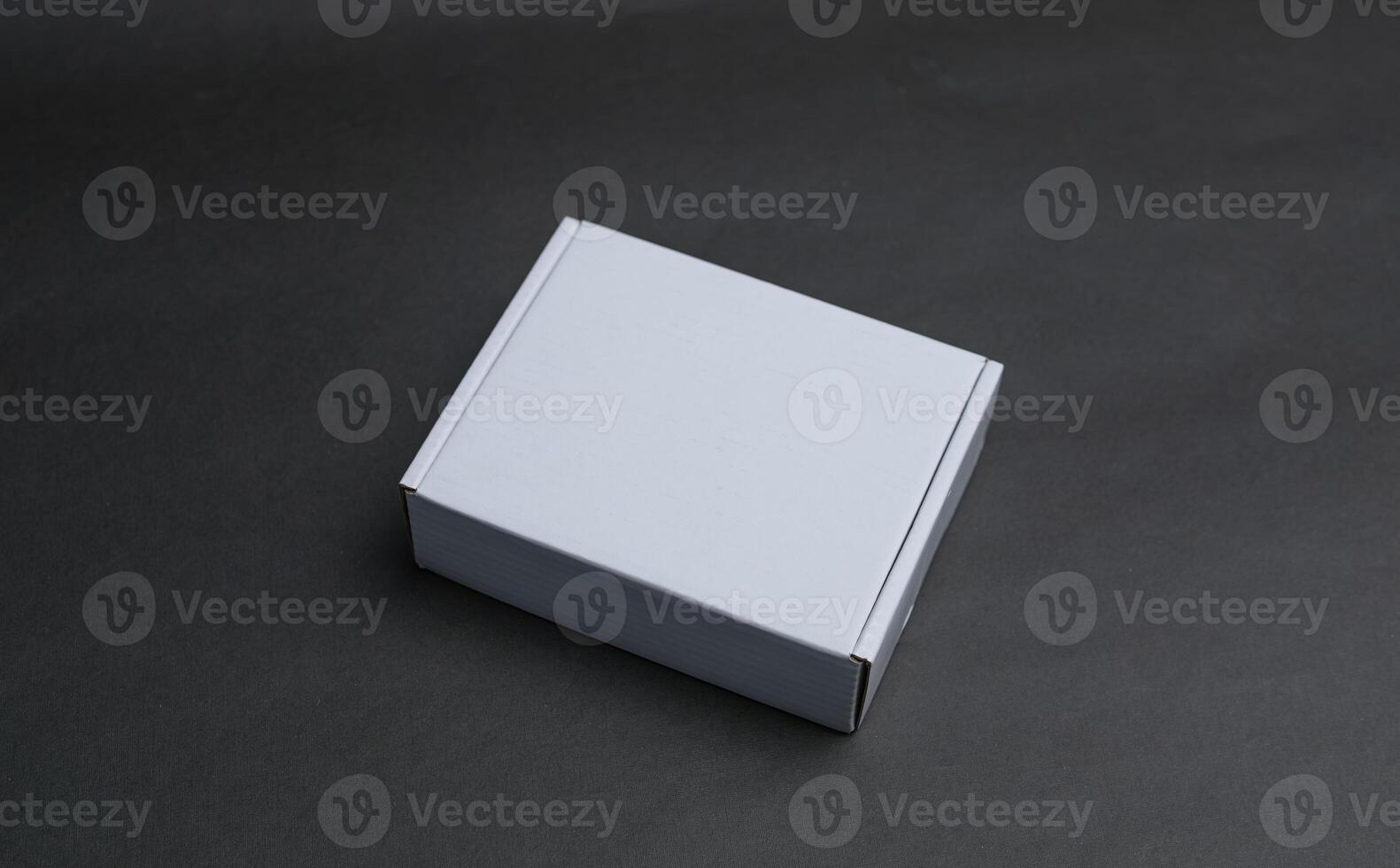 A white box is laying flat on a dark surface photo