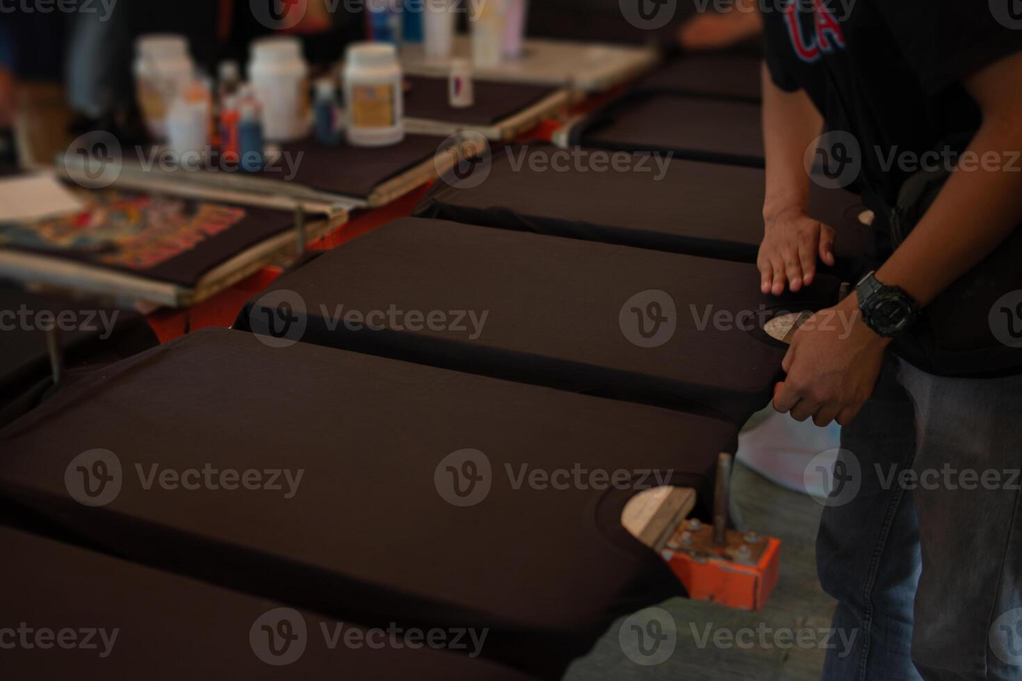 Black shirts laying flat on a printing table photo