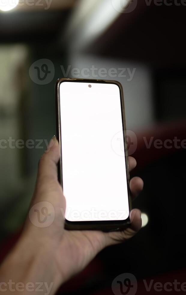 A hand holding a smartphone with a blank white screen photo