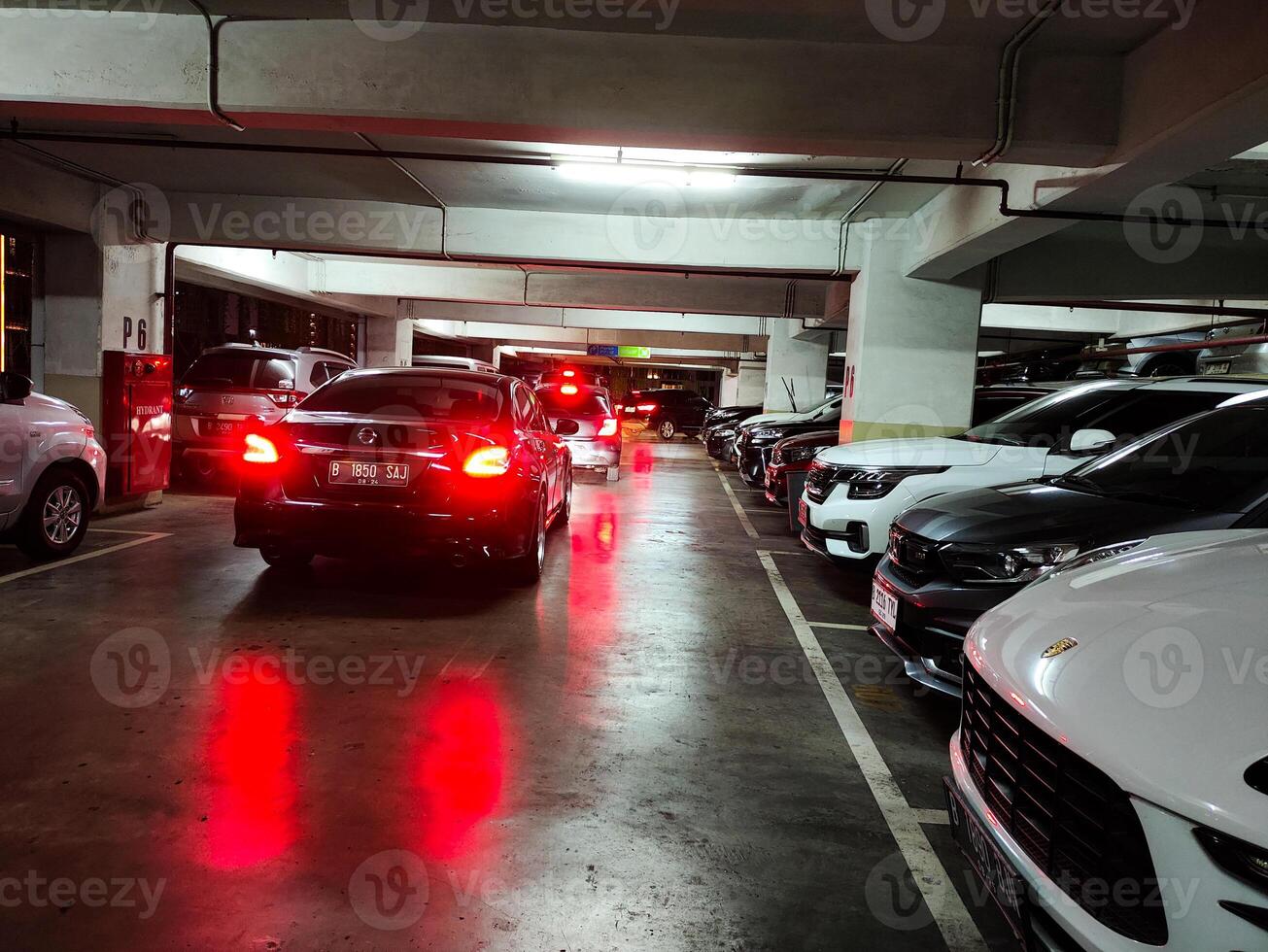 Indoor Parking Lot Filled with Cars in a Busy Urban Garage with Low Lighting photo