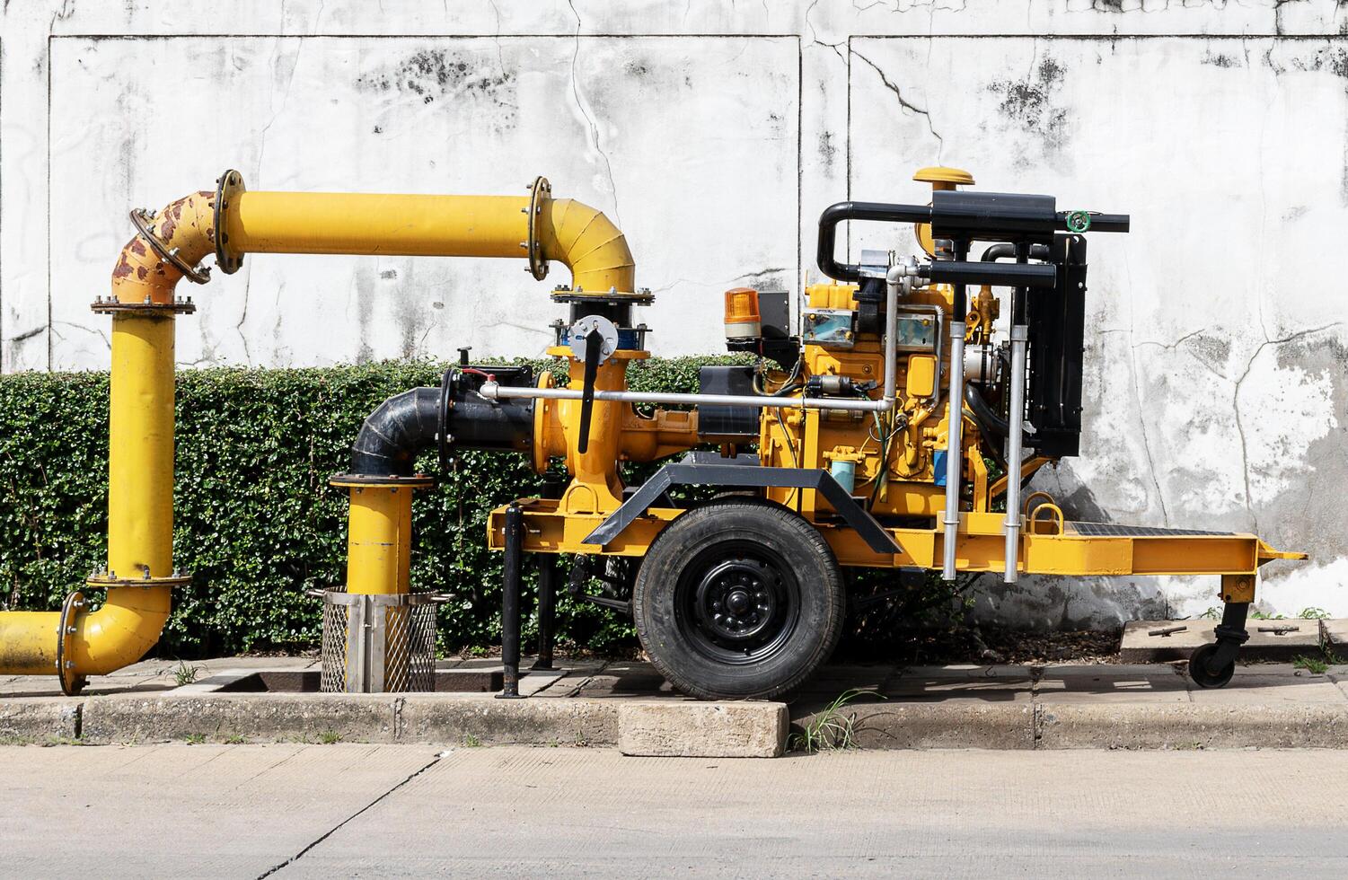 Yellow water pump on footpath photo