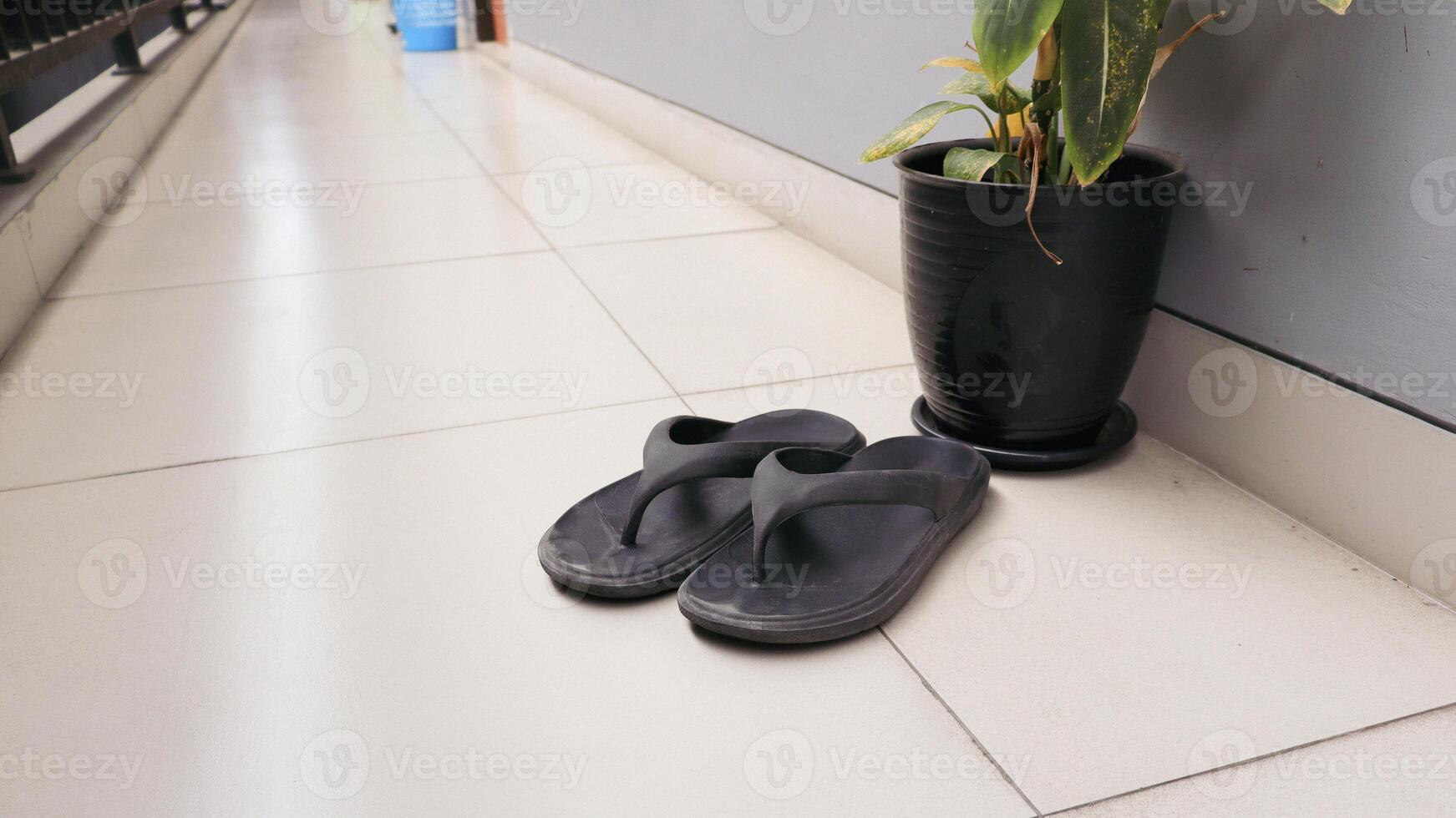 Black flip flops outside the house photo