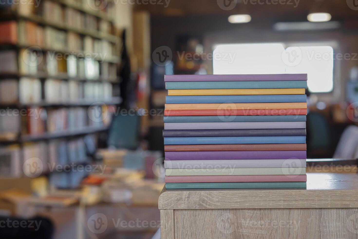 Stack of colorful books on wooden desk in the library room background. Education and knowledge concept. Pile of books to read. photo