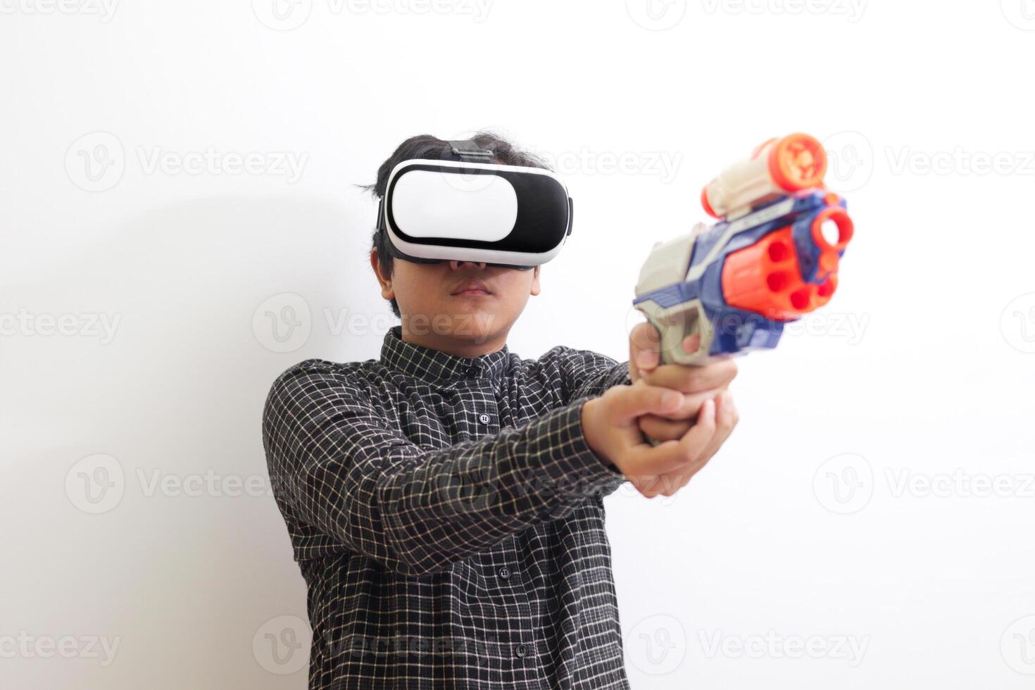 Portrait of Asian man in black plaid shirt using Virtual Reality VR glasses holding a gun weapon console. Isolated image on white background photo