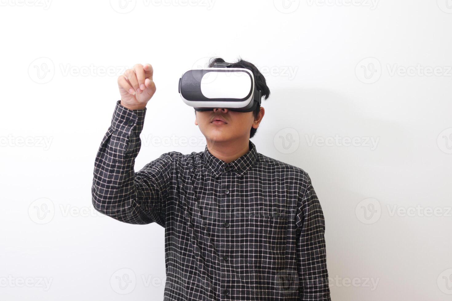 Portrait of Asian man in black plaid shirt using Virtual Reality VR glasses and trying to touch something in front of him. Isolated image on white background photo