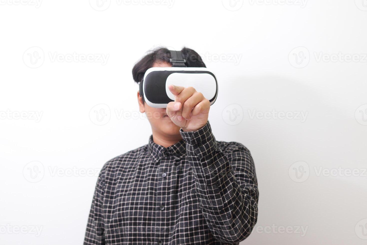 Portrait of Asian man in black plaid shirt using Virtual Reality VR glasses and trying to touch something in front of him. Isolated image on white background photo