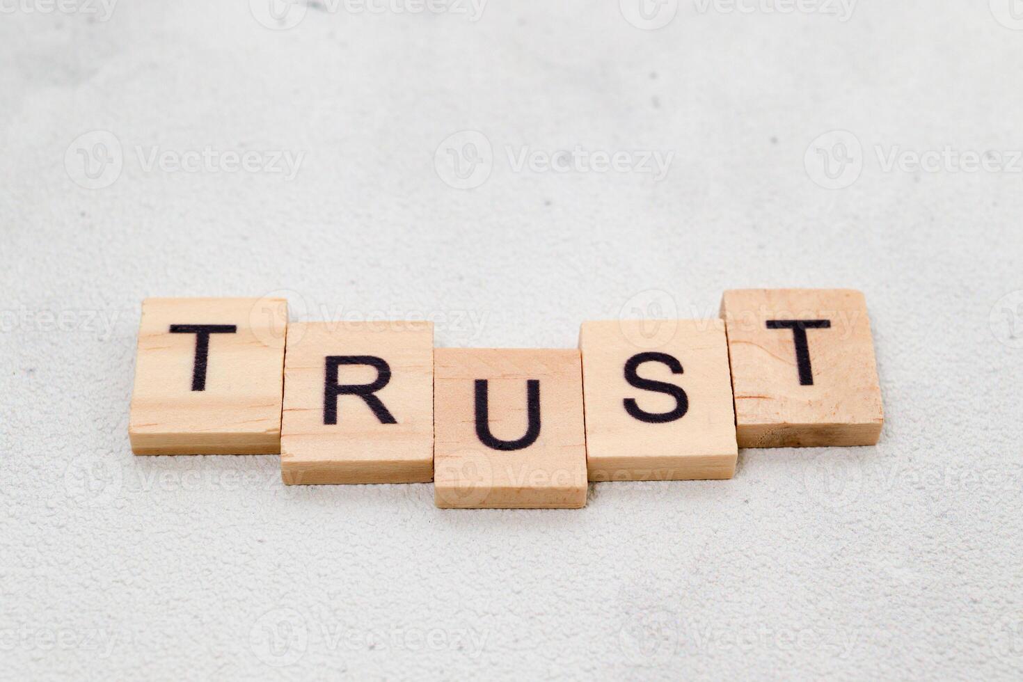 Top view of Trust word on wooden cube letter block on white background. Business concept photo