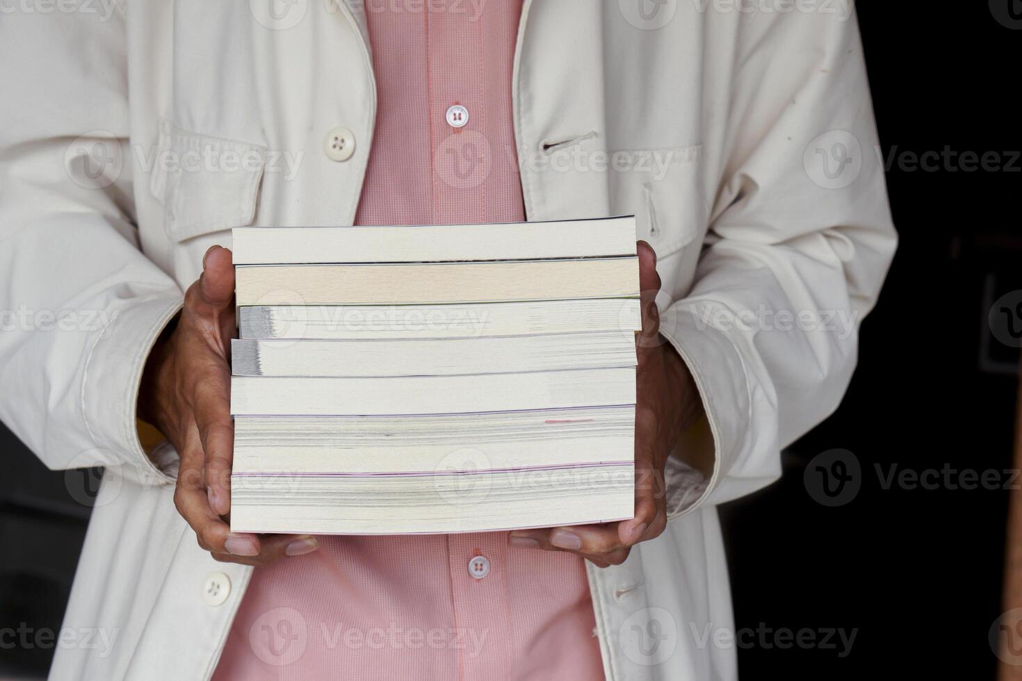 Male hand holding a stack of books. Education and knowledge concept. Portrait of young man book lover photo