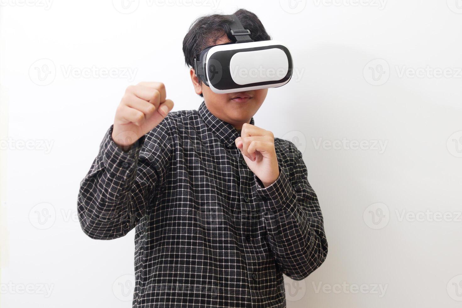 Portrait of Asian man in black plaid shirt using Virtual Reality VR glasses and trying to punch and fight something or his enemy game in front of him. Isolated image on white background photo