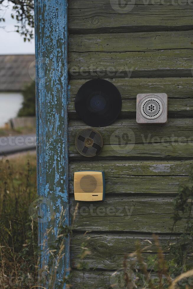 All sorts of junk hangs on the wall of a wooden, rustic house photo
