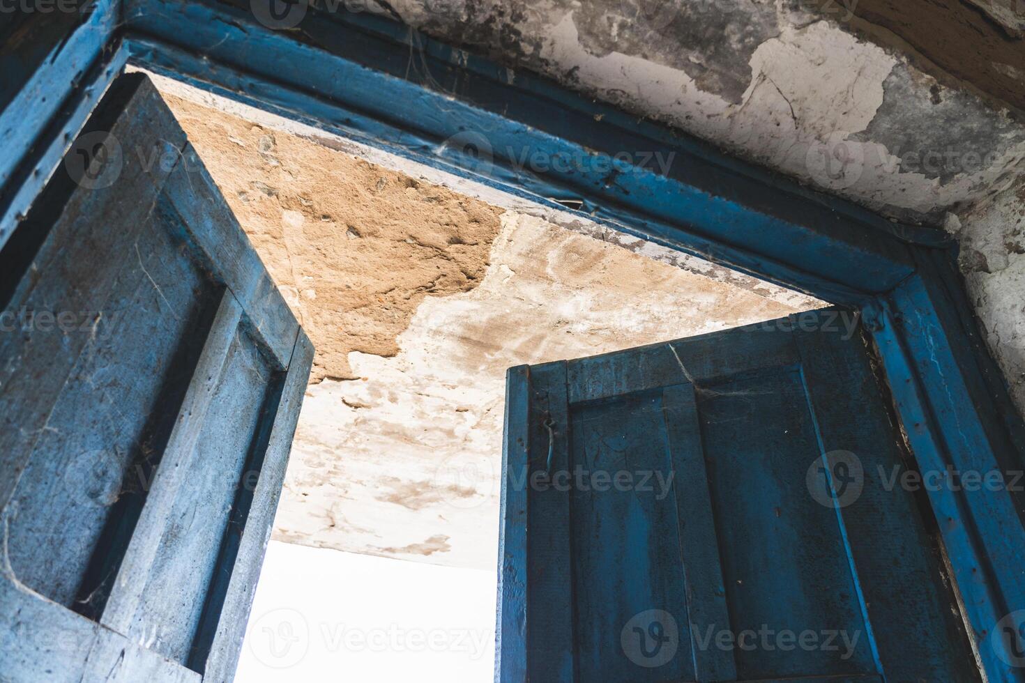 The open, blue doors of the main entrance, to an abandoned, rustic store photo