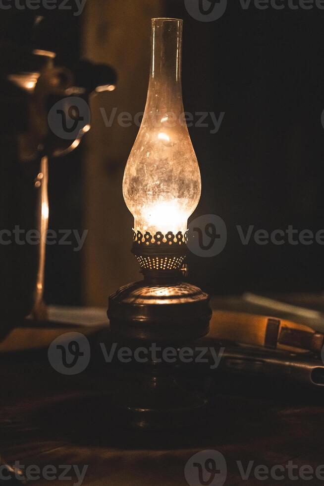 An old Soviet rifle lies on a table next to a kerosene lamp in the semi-darkness photo