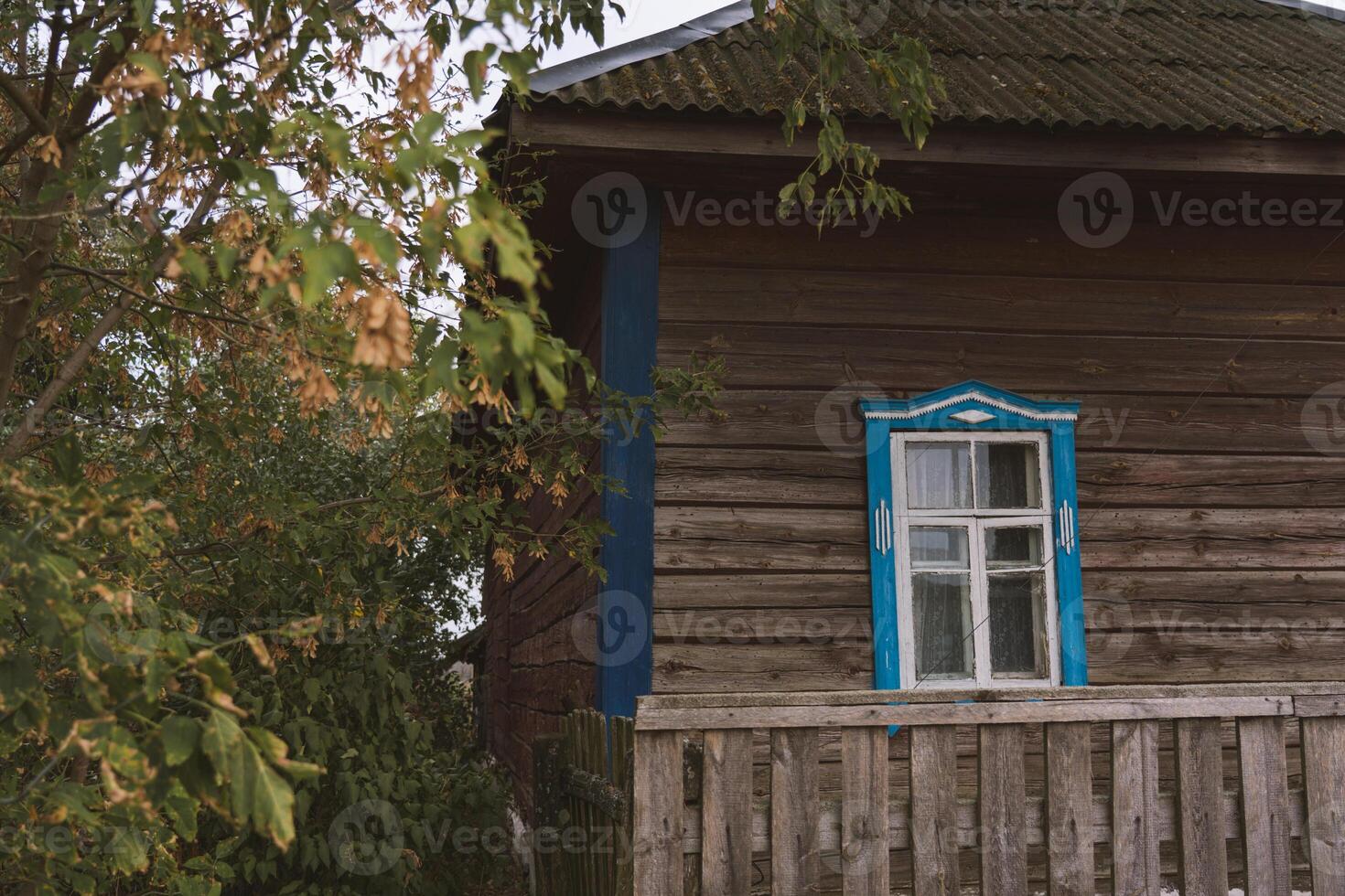 Rustic house with blue windows in the evening in the village photo