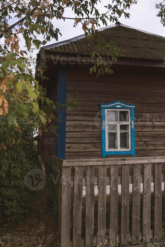 Rustic house with blue windows in the evening in the village photo