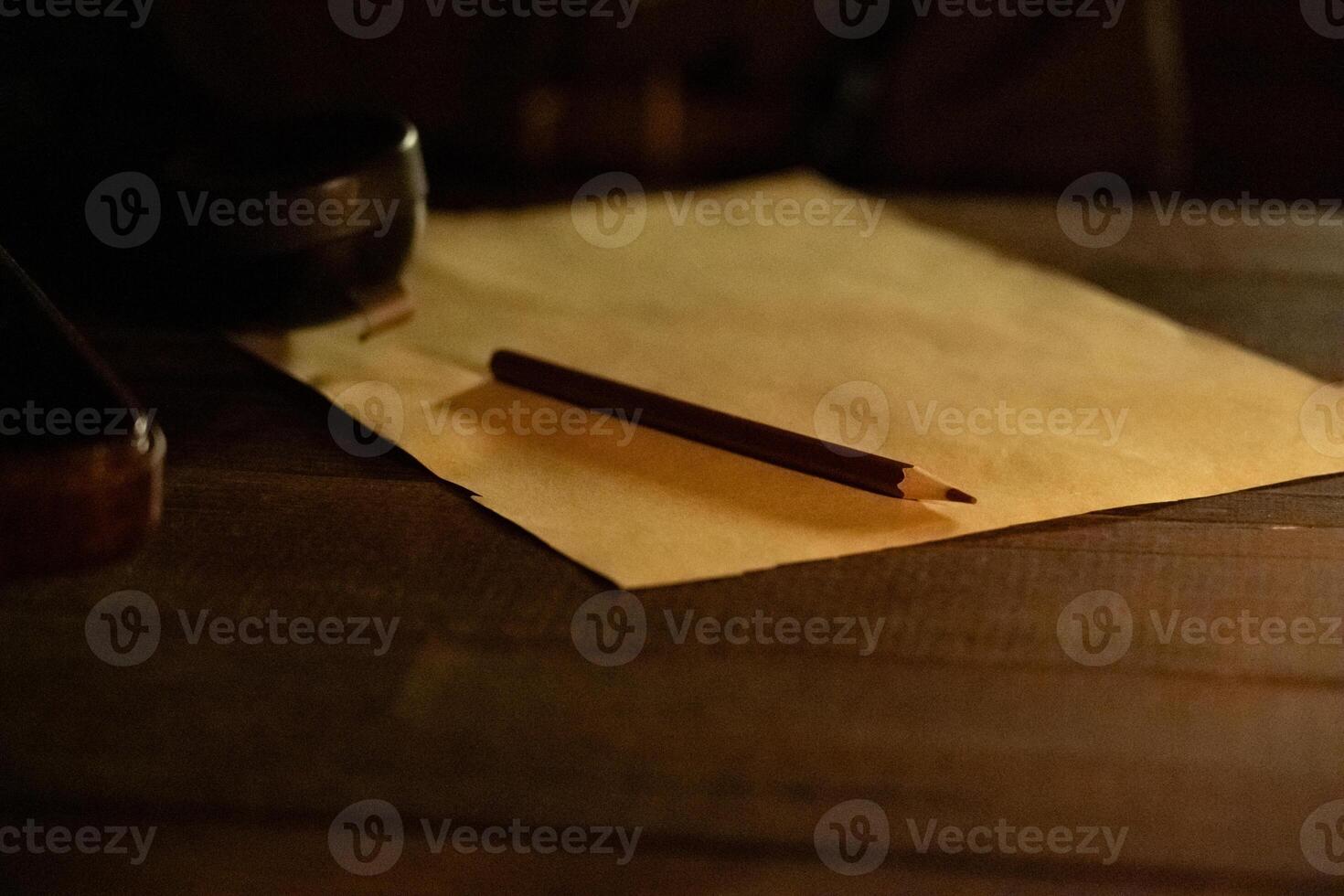 A sheet of paper with a pencil on the table in the dugout in the semi-darkness photo