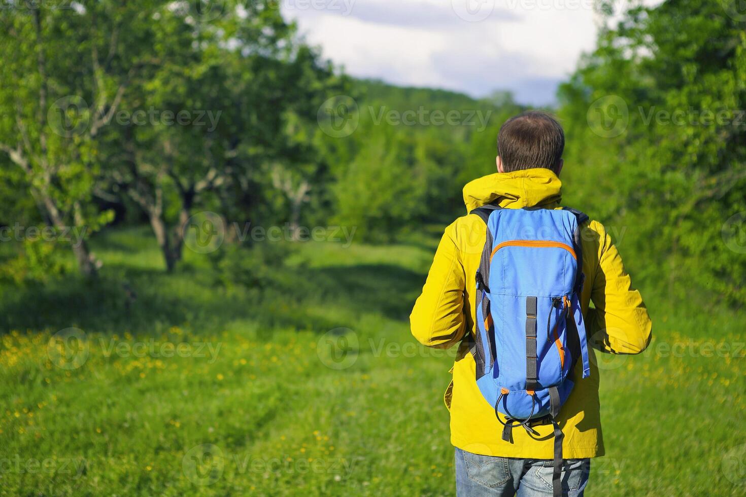 Man with backpack hiking in forest photo