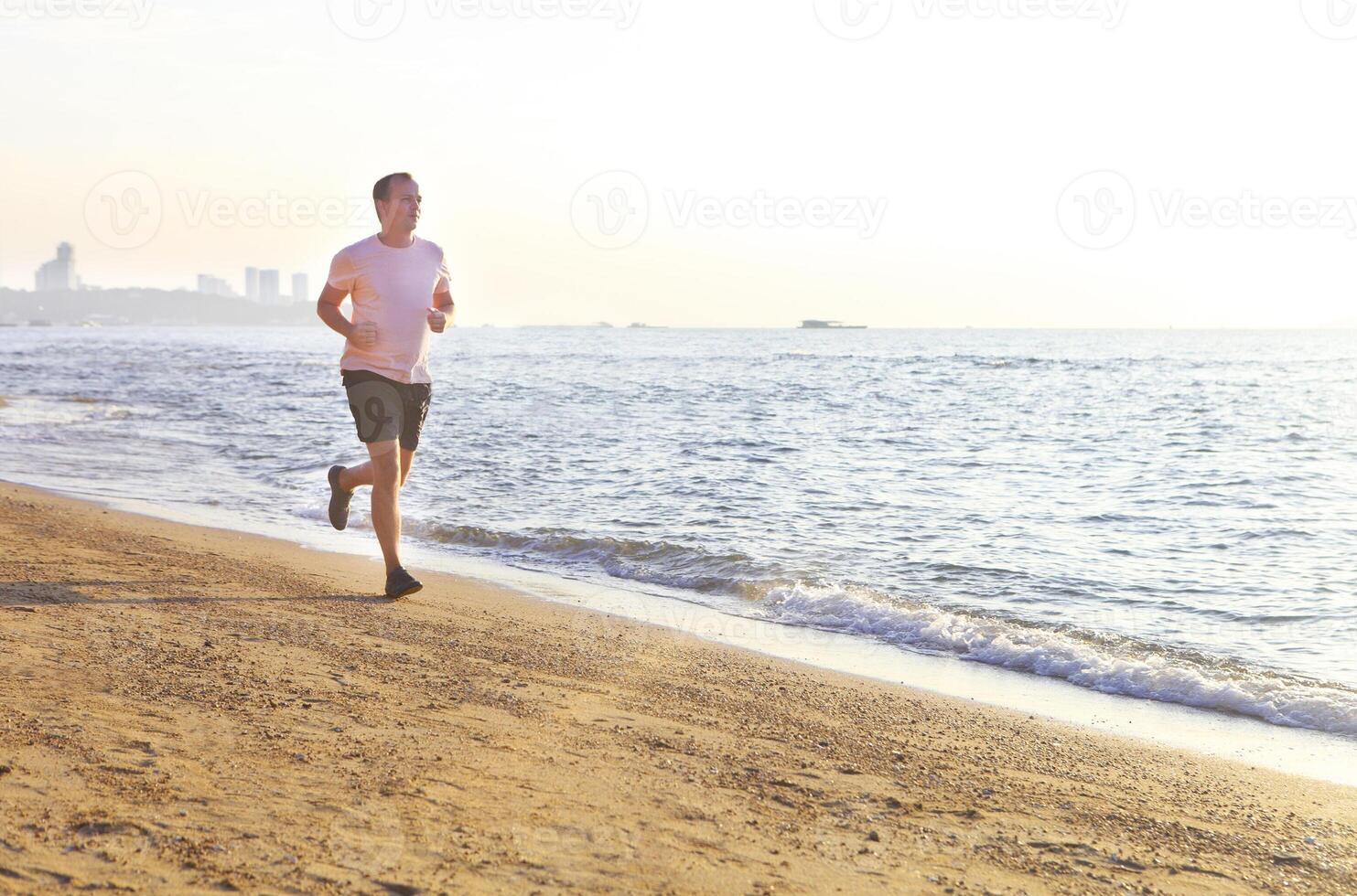 Man running on the beach at surise photo
