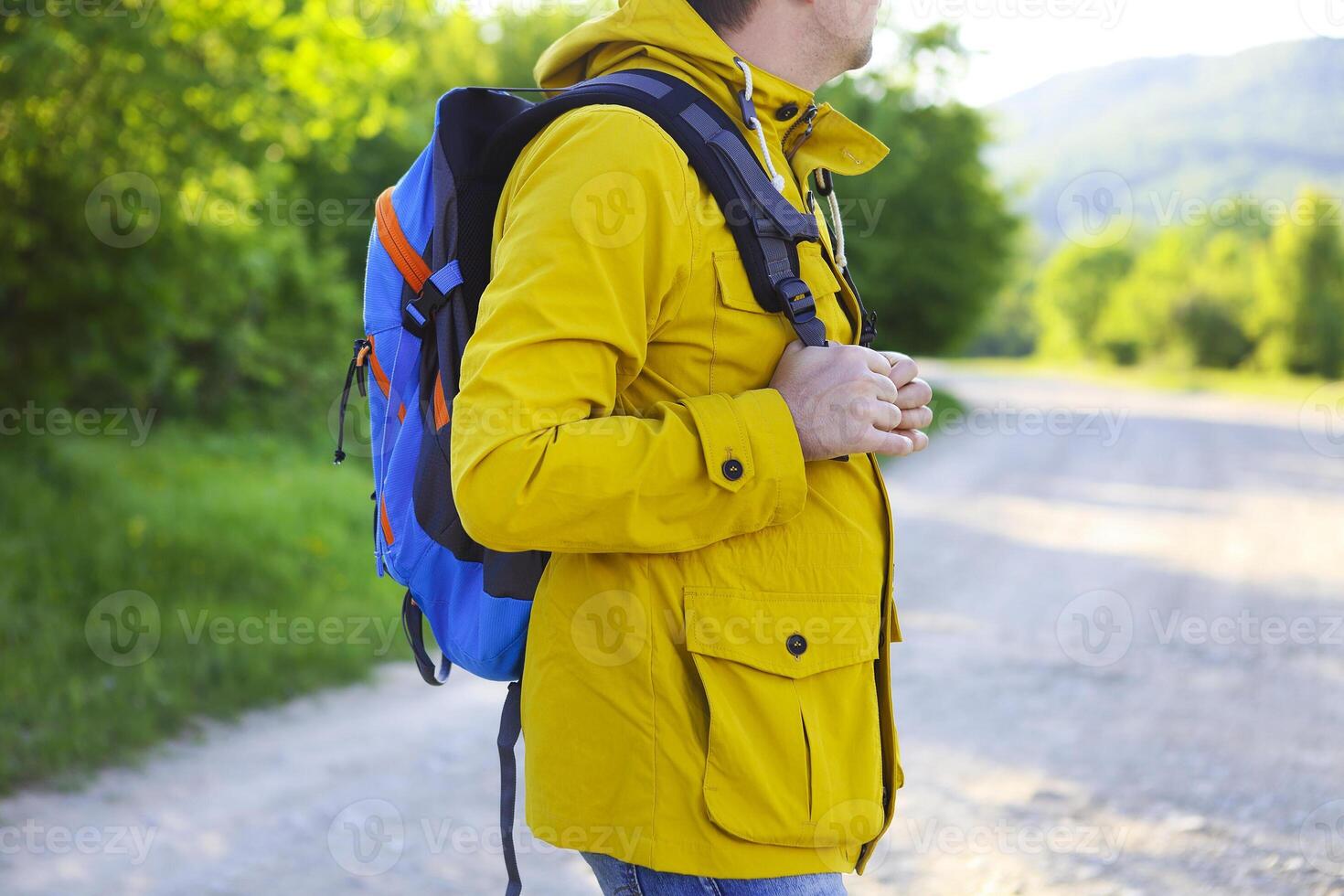 Side view of young man with backpack hiking photo