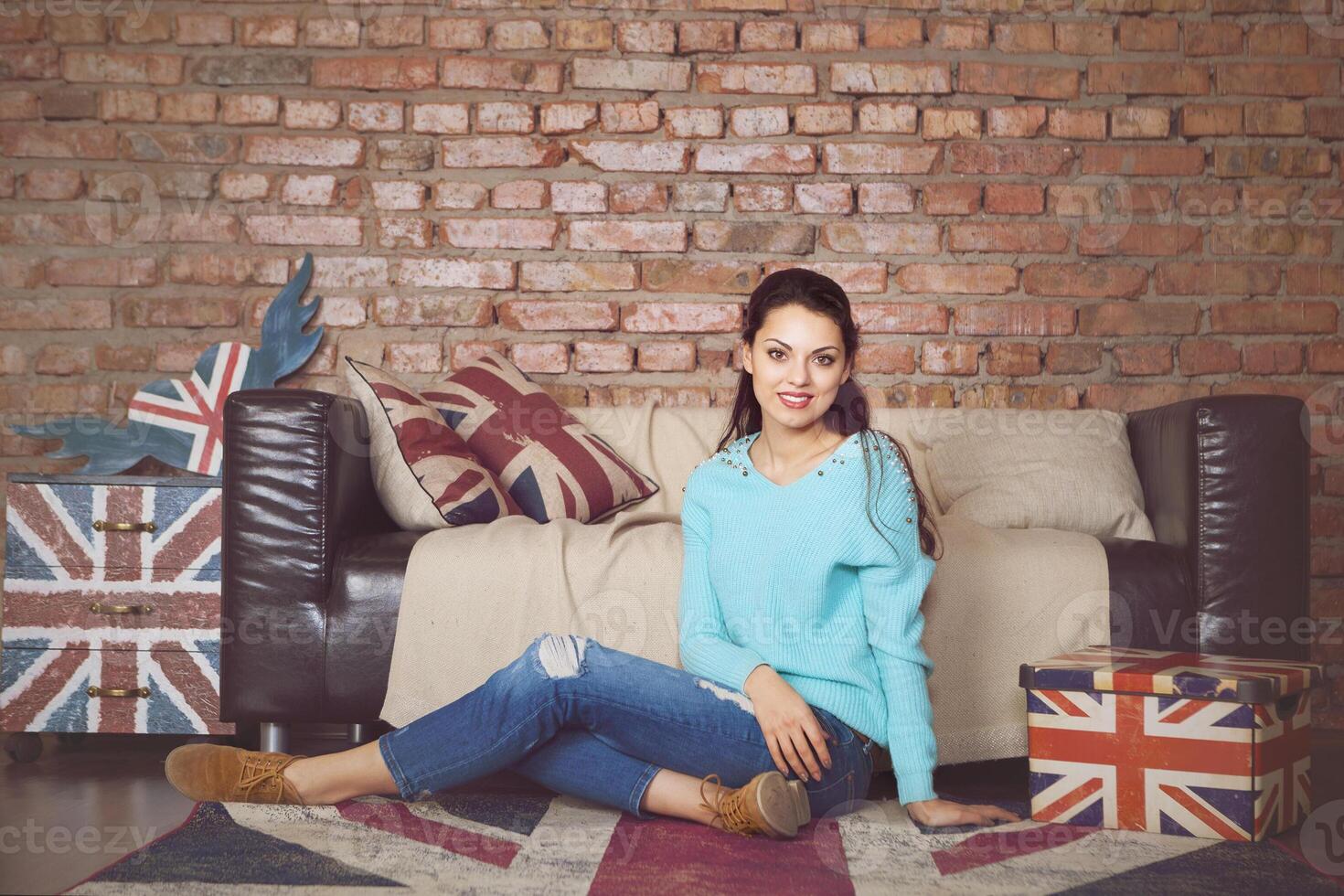 Pretty hipster girl sitting near the couch at home photo