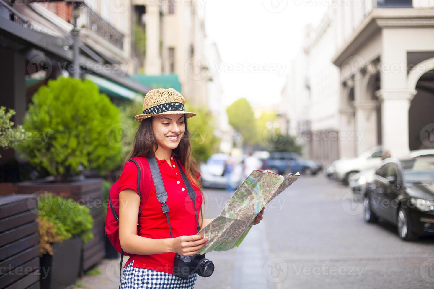 Portrait of a beautiful female tourist searching a place on the map photo