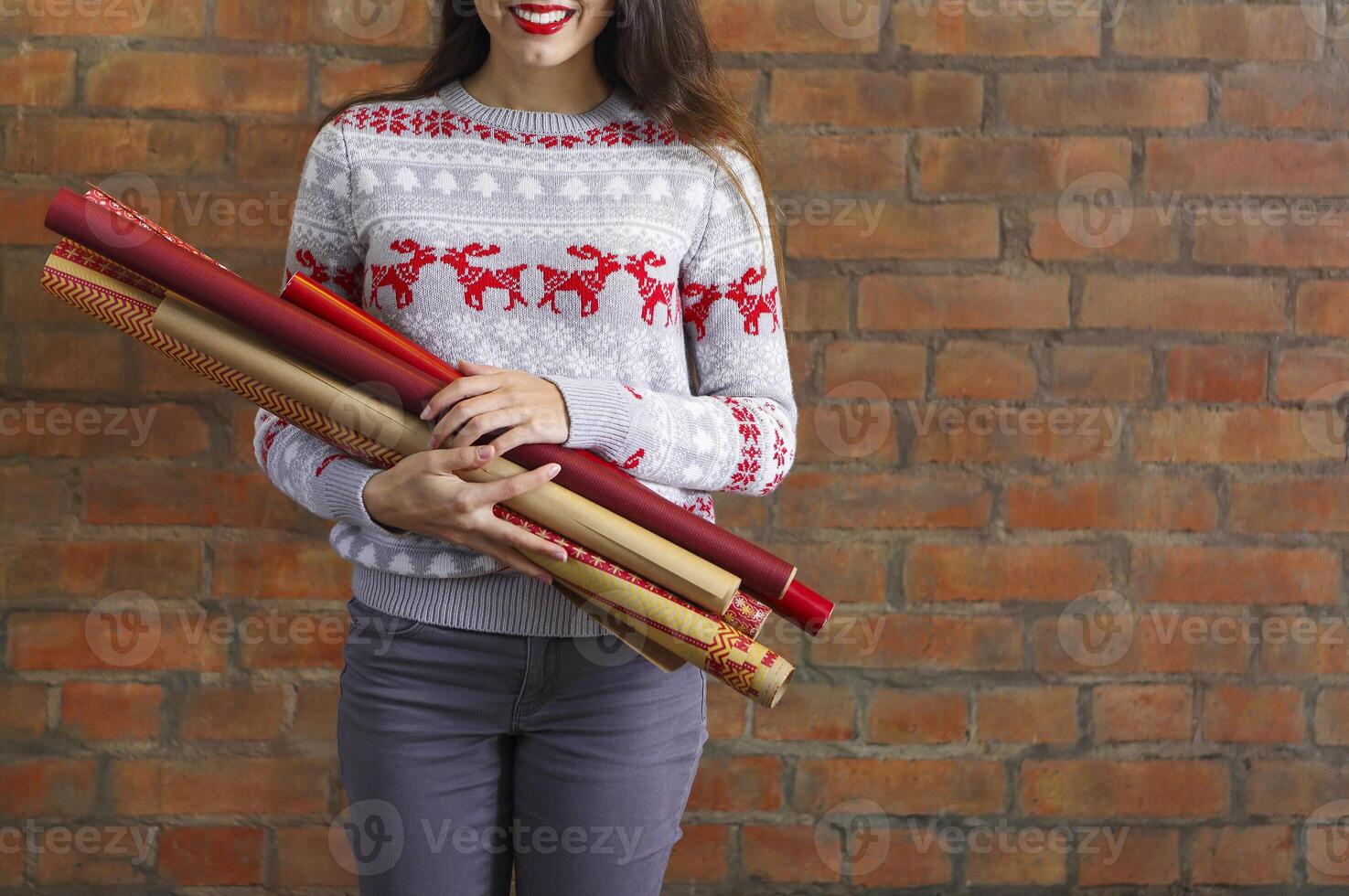 Young woman holding hands closeup wrapping kraft paper rolls for gifts photo
