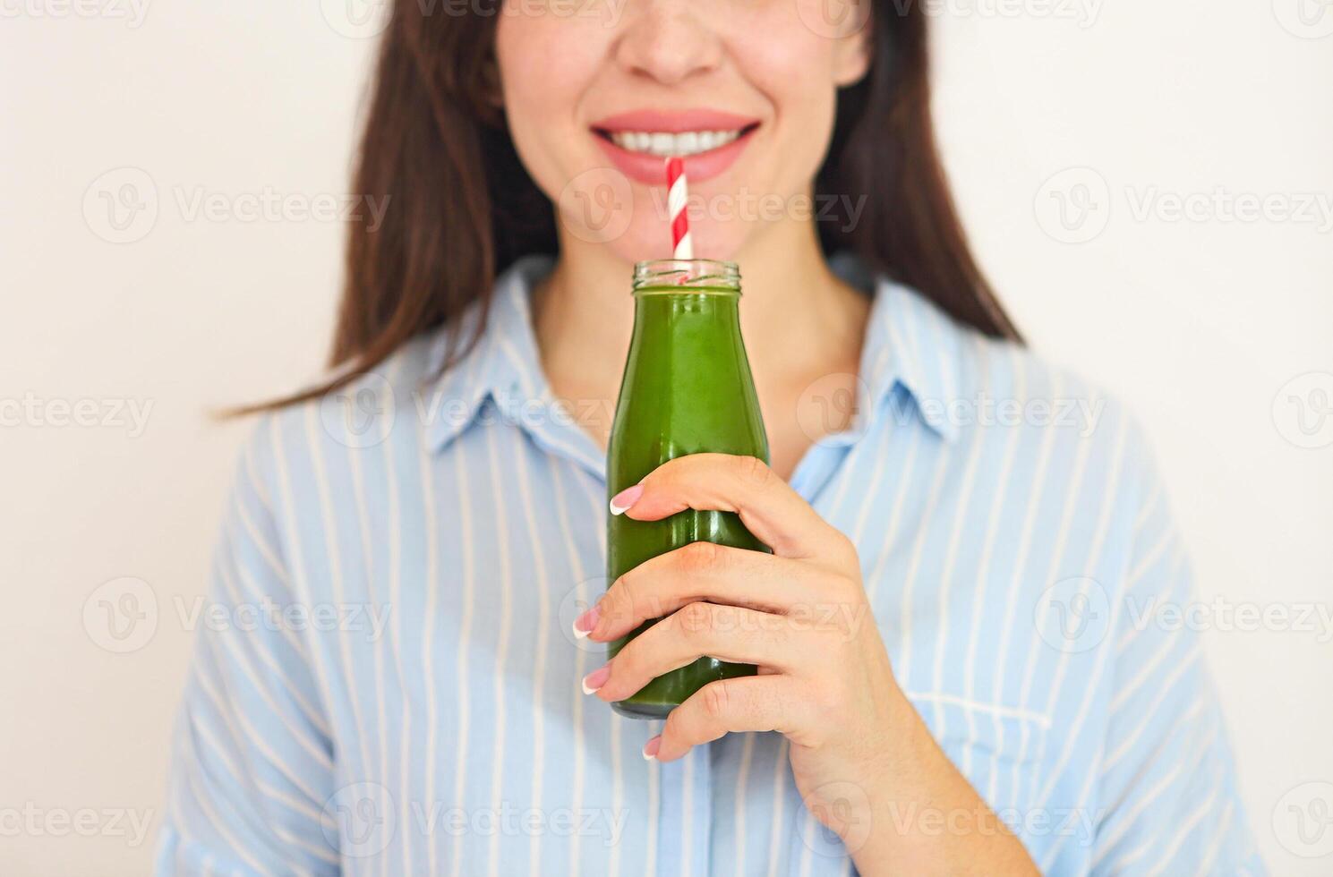 Closeup of happy beautiful fit girl with fresh green juice photo