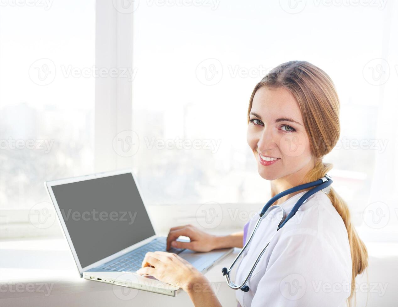 Portrait of young woman doctor at computer photo