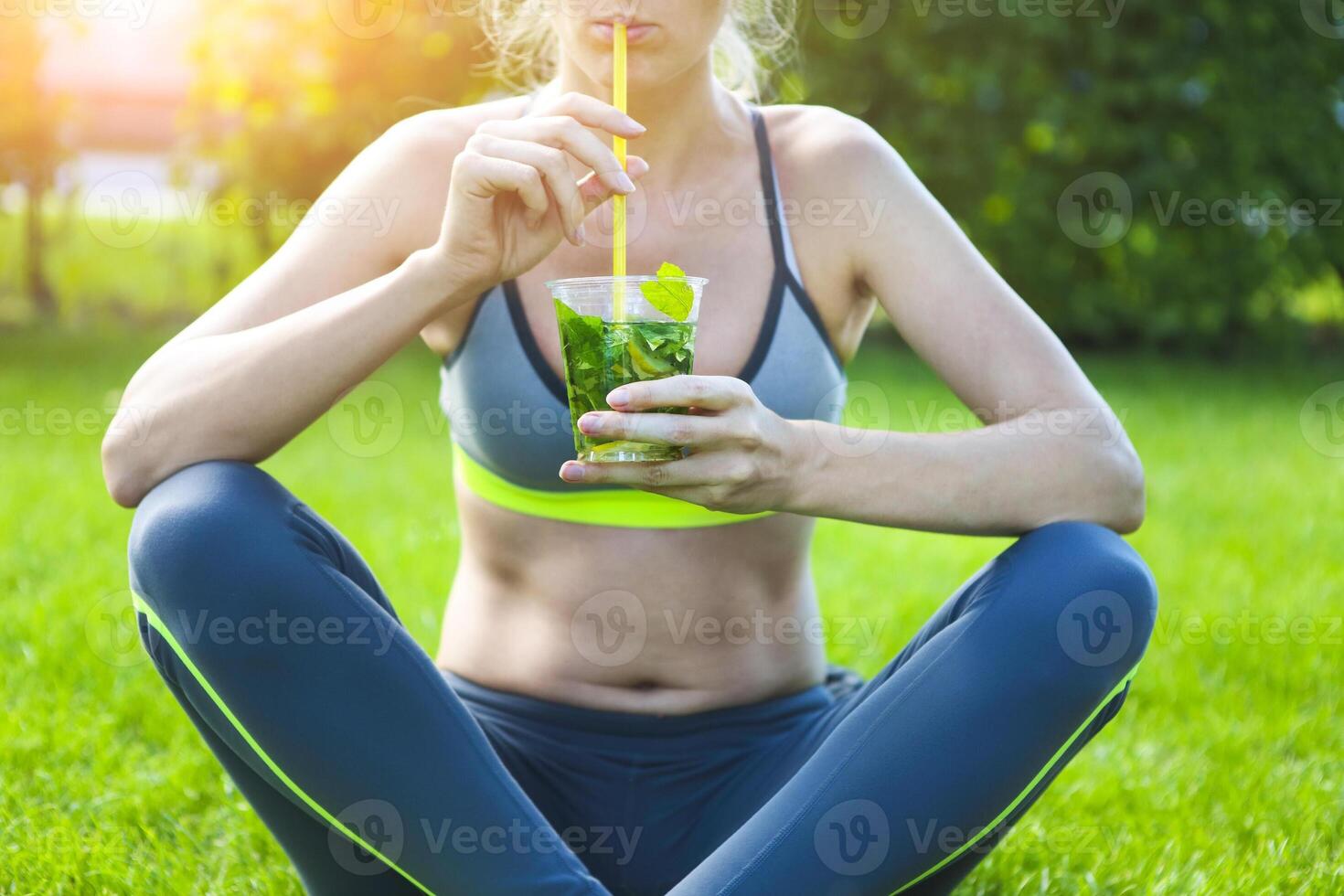Woman drinking after fitness running workout on summer day. photo