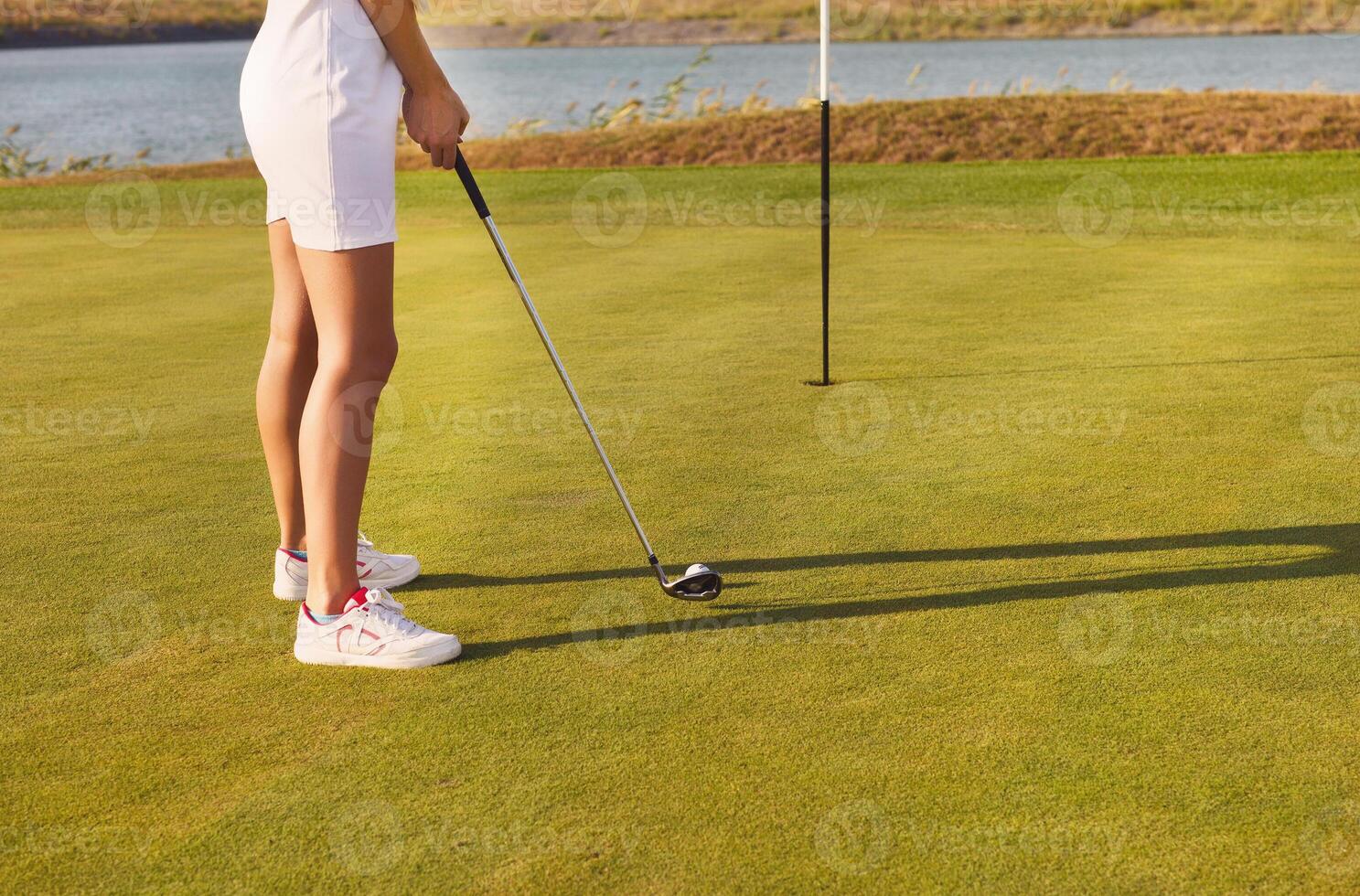 Golf player practicing to hit the ball at the course photo