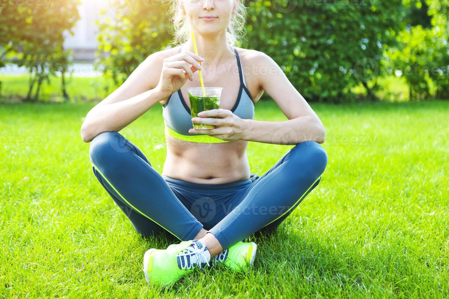 Woman drinking after fitness running workout on summer day. photo