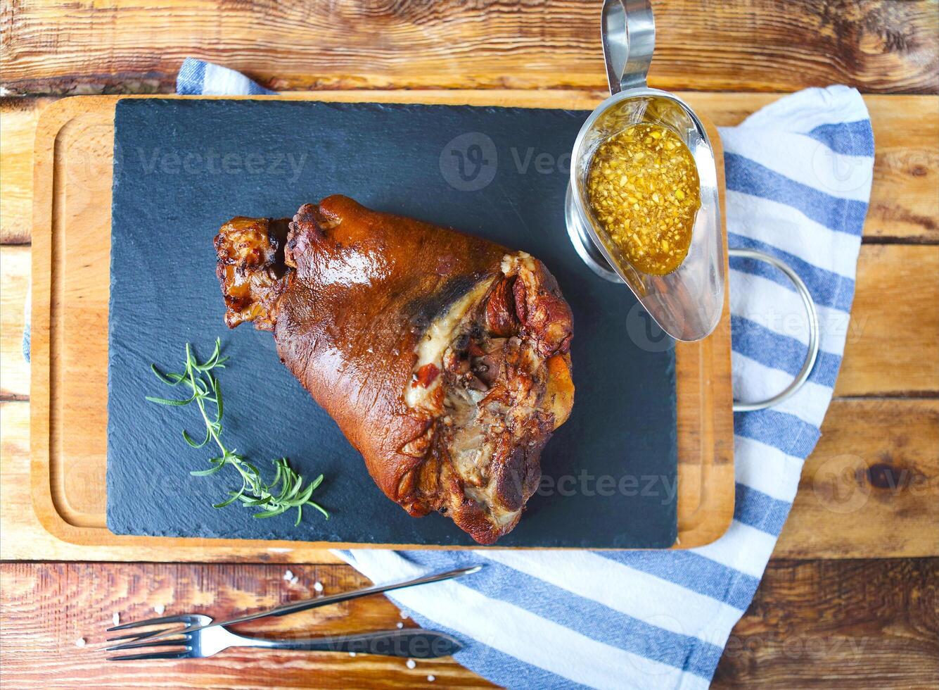 Roasted pork leg served on the wooden table photo