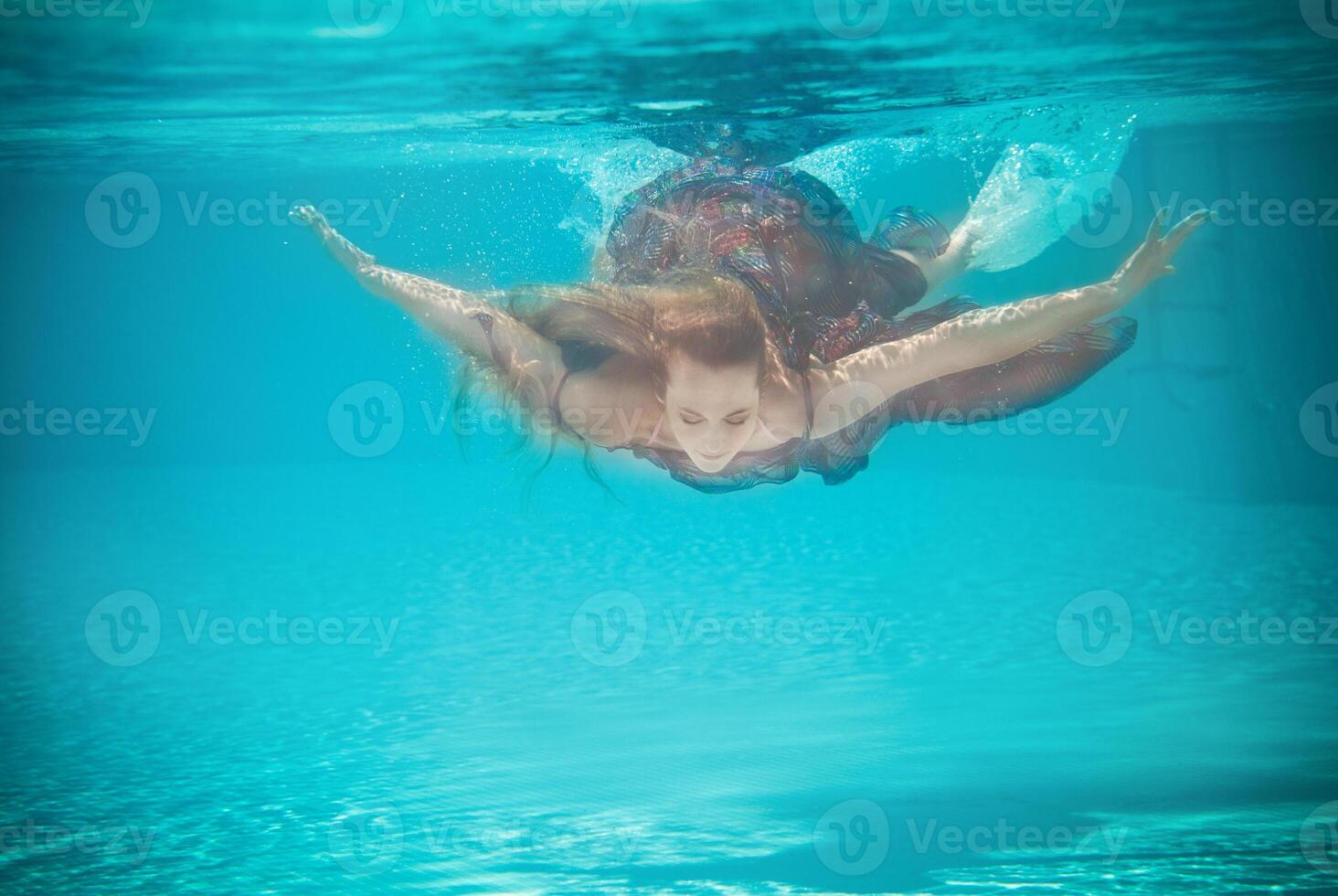 Underwater woman portrait in swimming pool photo